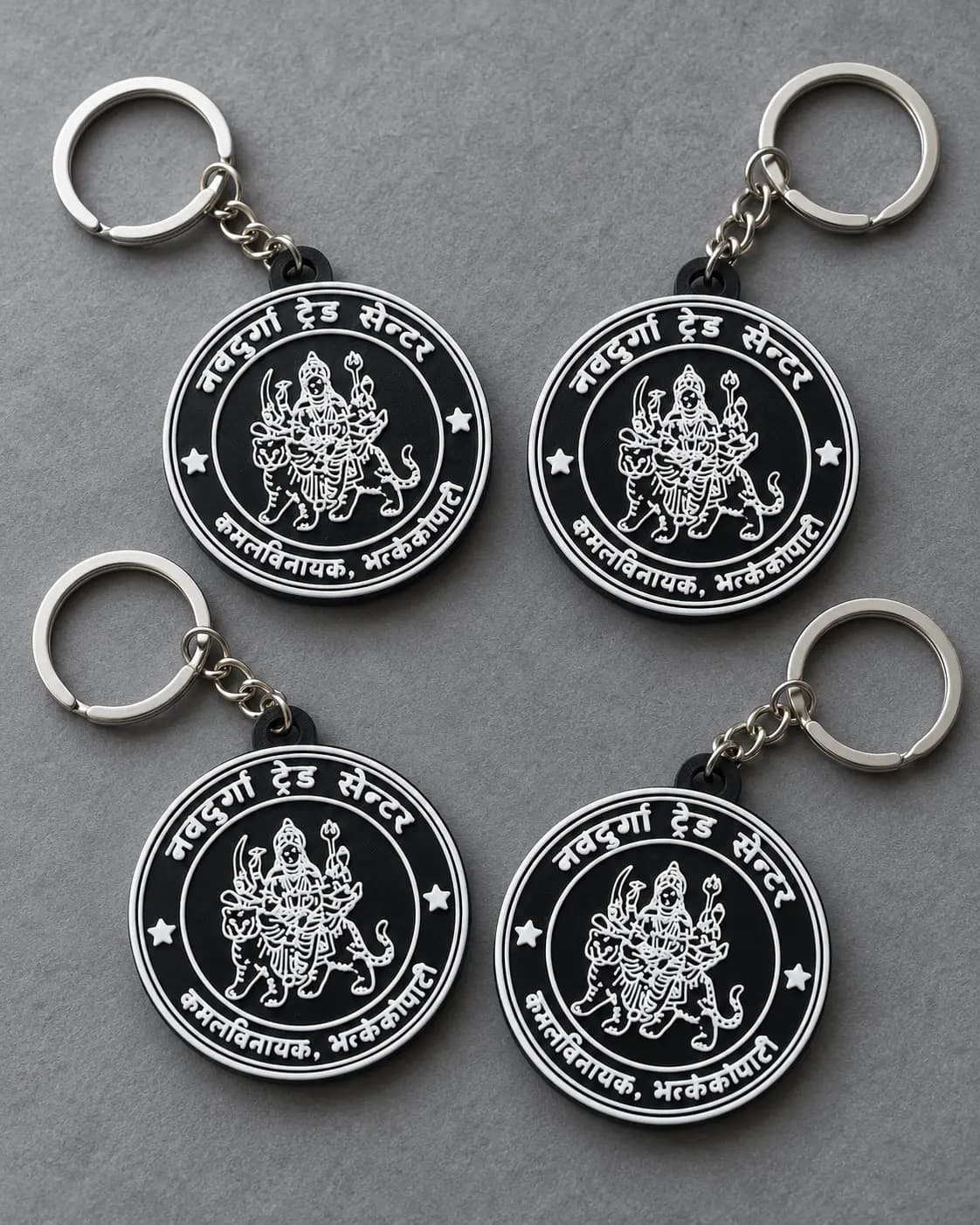 Black round keyrings with a detailed emblem and Nepali lettering