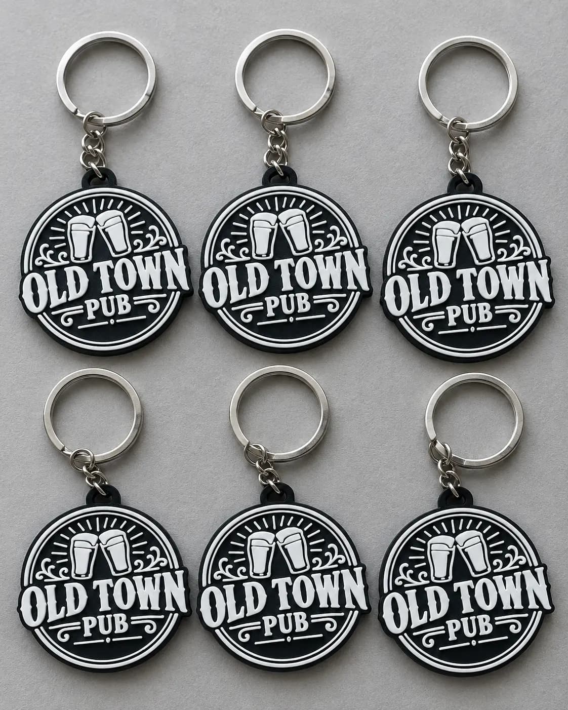 Six black Old Town Pub logo keyrings with white detailing
